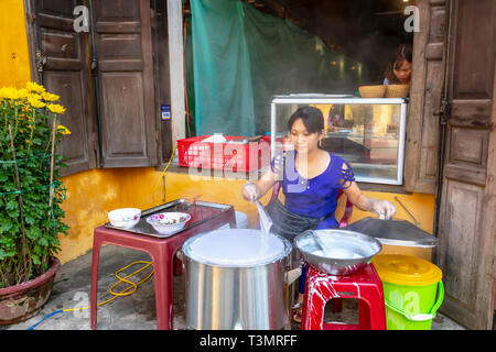 Donna vietnamita rendendo la carta di riso torte su una strada laterale nel quartiere vecchio di Hoi An, Quang Nam Provence, Vietnam Asia Foto Stock