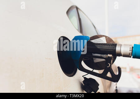Grigio auto presso la stazione di gas essendo riempito con carburante Foto Stock