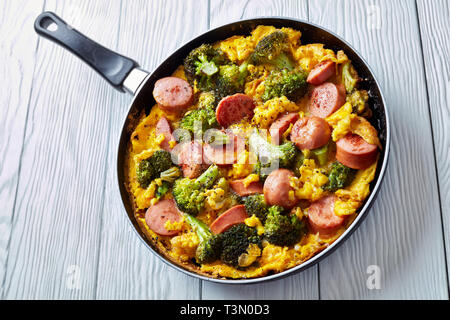Deliziosi hot frittata con broccoli e salsicce in una padella cosparsi di pepe peppe, vista orizzontale dal di sopra, close-up Foto Stock