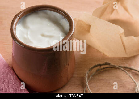 White yogurt fatto in casa in un vaso di argilla. Foto Stock