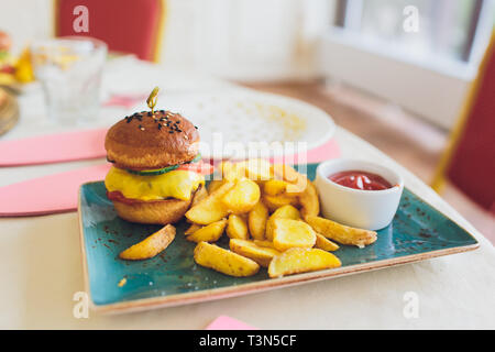 Per i pasti dei bambini con pane e patatine fritte Mini Hamburger Hamburger Foto Stock