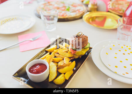 Per i pasti dei bambini con pane e patatine fritte Mini Hamburger Hamburger Foto Stock