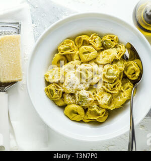 Piatto di ravioli italiani con formaggio parmigiano sulla piastra di italiano cotto tortellini Ravioli con formaggio parmigiano sul tavolo. Mediterrane sani Foto Stock