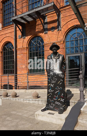 Una scultura raffigurante il poeta polacco Julian Tuwim di fronte la moderna Vienna Casa Andel's nel complesso Manufaktura a Lodz. La Polonia. Foto Stock