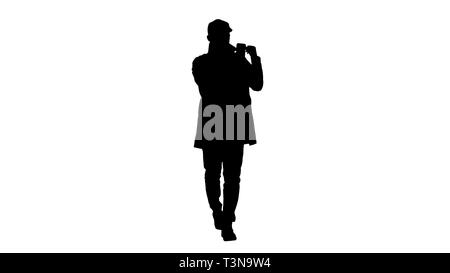 Silhouette autunno stile di moda uomo la registrazione di video blog a piedi. Foto Stock