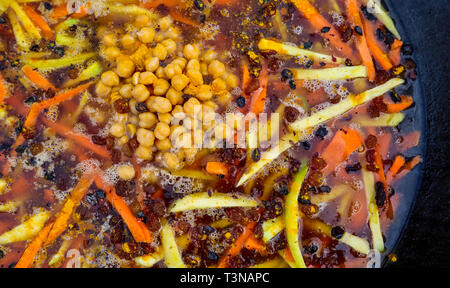 Riso pilaf in un grande cast-calderone di ferro sul fuoco Foto Stock