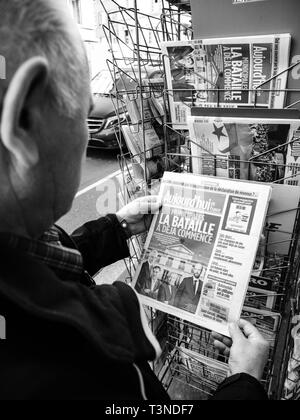 Parigi, Francia - 29 Mar 2019: Edicola chiosco vendita di premere con maschio senior di mano più recente acquisto dotate sul coperchio anteriore Foto Stock