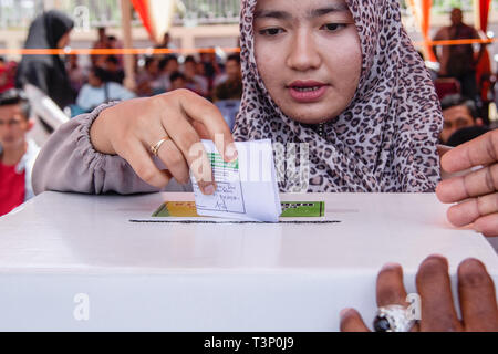 Lhokseumawe, Indonesia. Xi Apr, 2019. Una donna si vede la colata il suo voto durante il pre-elettorale per trapano presidente, vice-candidati presidenziali e legislative in candidati Lhokseumawe, provincia di Aceh, Indonesia. Elezioni in Indonesia avrà luogo la prossima settimana il Mercoledì 17 Aprile, 2019. Credito: SOPA Immagini limitata/Alamy Live News Foto Stock