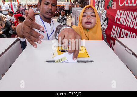 Lhokseumawe, Indonesia. Xi Apr, 2019. Una donna si vede la colata il suo voto durante il pre-elettorale per trapano presidente, vice-candidati presidenziali e legislative in candidati Lhokseumawe, provincia di Aceh, Indonesia. Elezioni in Indonesia avrà luogo la prossima settimana il Mercoledì 17 Aprile, 2019. Credito: SOPA Immagini limitata/Alamy Live News Foto Stock