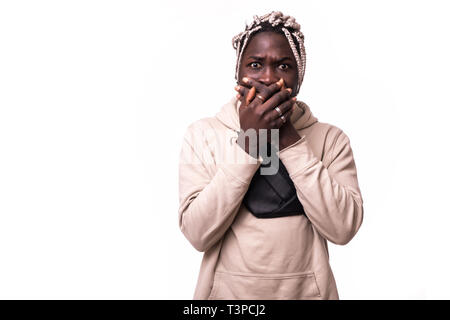 Ritratto di giovane di carnagione scura studente uomo guardando la telecamera con sorpresa colpevole espressione, facendo qualcosa di sbagliato, che copre la sua bocca. Foto Stock