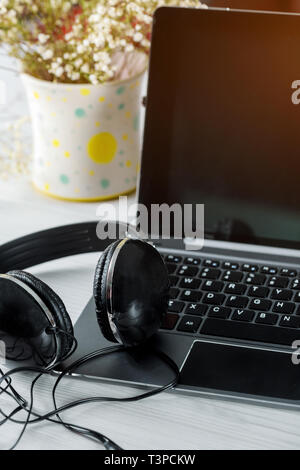 Le cuffie con il computer portatile su un laptop computer tastiera Foto Stock