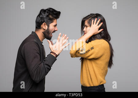 Emotional coppia giovane quarreling isolato su bianco Foto Stock