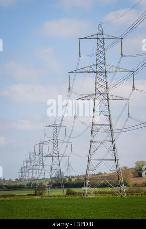 Una linea di energia elettrica tralicci marzo attraverso la campagna inglese a sud di Oxford Foto Stock