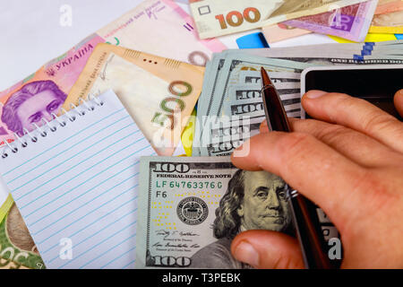 Denominazioni delle ucraino grivna delle bollette in sotto le bollette un frammento del dollaro statunitense Bill. Foto Stock