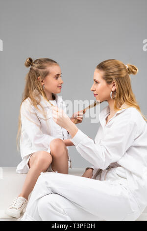 Buona-cercando simile alle ragazze di età diverse seduto di fronte a ciascun altro Foto Stock