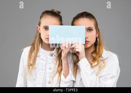Appello di buona cercando simile ragazze in abiti bianchi che porta targa dati trasparente Foto Stock