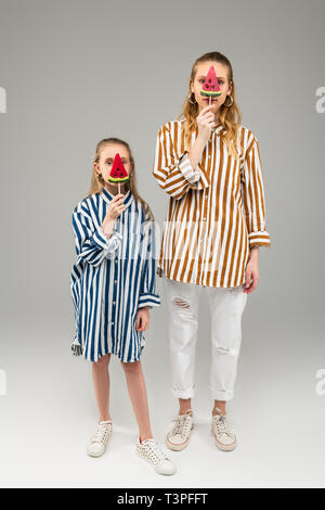 Buona ricerca con i capelli lunghi le ragazze in strisce luminose camicie di contenimento a forma di anguria candy Foto Stock