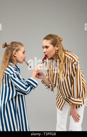 Curioso belle ragazze di magliette funky degustazione ogni altri dolci Foto Stock