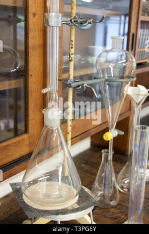 Antica scienza attrezzature per esperimenti chimici e produrre. Vintage di bottiglie di vetro sul tavolo di legno, primo piano Foto Stock