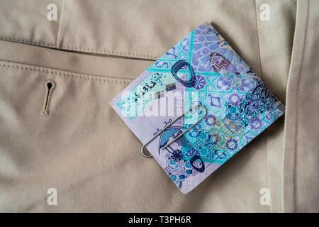 Qatar Riyal rileva la caduta di pantaloni pantaloni o tasche Foto Stock