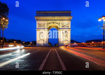 Via Parigi di notte con l'Arc de Triomphe in Paris, Francia. Foto Stock