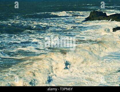 Onde tempestose con schizzi e schiuma sulla superficie dell'oceano durante una tempesta Foto Stock