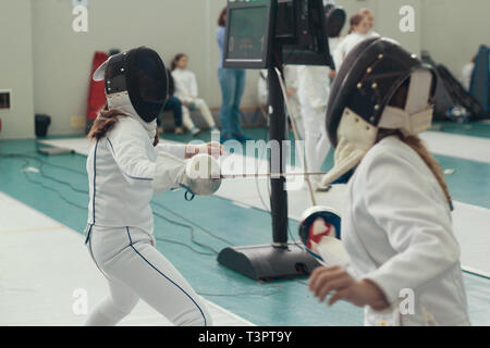 Due ragazze giovani schermitori avente la scherma duello sul torneo Foto Stock