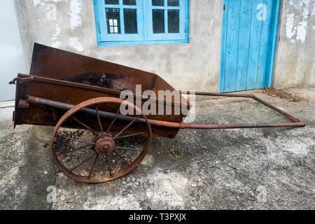 Vecchia fattoria carrello con due whells in piedi vicino a casa. Foto Stock