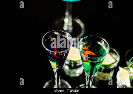 Gustosi e colorati bibite a base di alcoli diversi, sciroppi e liquori, unico effetto del barista di lavoro, party night Foto Stock