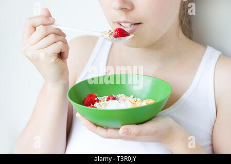 Donna sorridente mangiare muesli Foto Stock