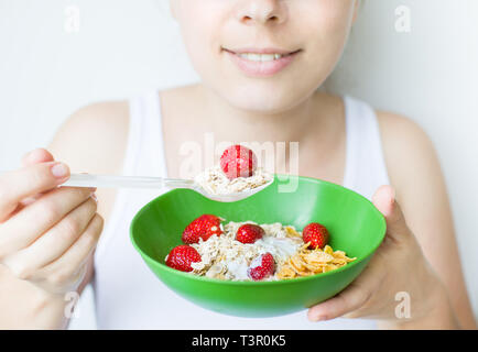 Donna sorridente mangiare muesli Foto Stock