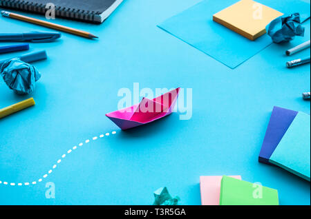 Direzione del business o i concetti di obiettivo con la barca di carta blu sul piano di lavoro background.successo di un investimento idee.situazione sfida Foto Stock