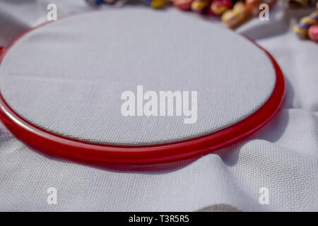 Telaio per ricamo con tela e luminose fili di cucitura. Foto Stock