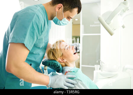 Dentista considera i denti del paziente ragazza Foto Stock