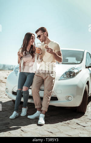 Positivo il piacere giovane appoggiato su di loro auto Foto Stock