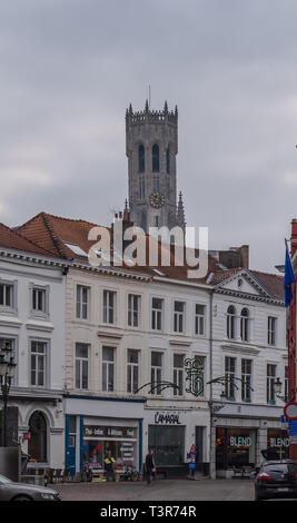 Bruges, Belgio - 14 dicembre 2018: la vecchia strada in Bruges con il campanile di Bruges, un campanile medievale, in background. Foto Stock