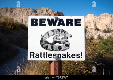 Attenzione rattlesnakes segno nel Parco nazionale Badlands, Dakota del Sud, STATI UNITI D'AMERICA Foto Stock