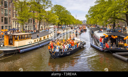 AMSTERDAM, Paesi Bassi - 27 Aprile 2018: Canal sfilata di barche sul Koningsdag re giorni di festeggiamenti. Compleanno del Re. Foto Stock