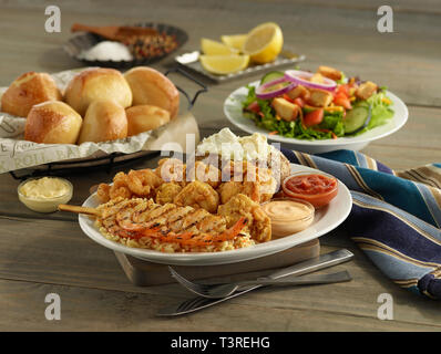 Fritti e gamberi alla griglia piatto cena con patate al forno, insalata e rotoli Foto Stock