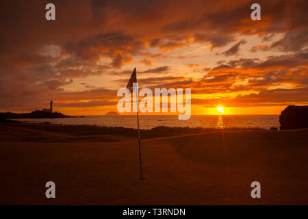 Turnberry Golf con il suo famoso faro e Ailsa Craig rock al tramonto. Foto Stock