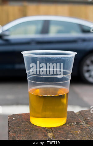 Auto parcheggiata e una mezza vuota becher in plastica di lager per illustrare il tema di bevuto / bere autista e guida in stato di ebbrezza. Inghilterra UK (108) Foto Stock