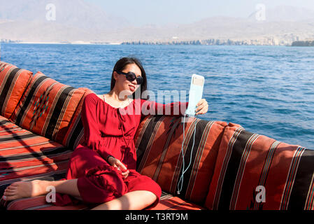 Donna con divertimento su una barca dhow crociera Foto Stock