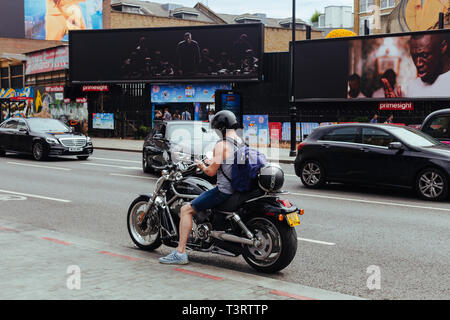 Londra/UK - 21 Luglio 2018: Uomo su una Harley Davidson Moto controllando il suo telefono cellulare su un lato della strada a Londra, Regno Unito Foto Stock