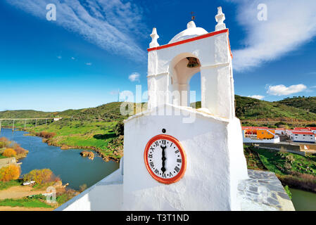 Bianco brillante lavato clock tower con vista fiume con il verde delle colline in una giornata di sole Foto Stock