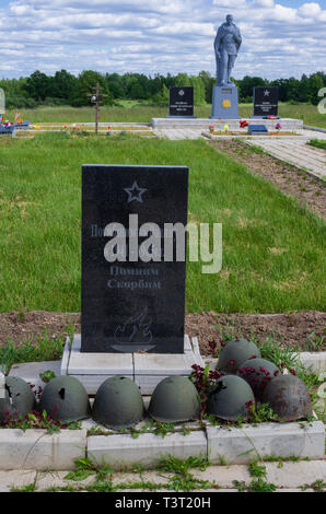 Combattere i caschi e iscrizione russo del memorial e il monumento al soldato sovietico alla linea Stalin memorial (Pskov Regione,Russia) Foto Stock