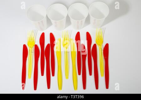 Rosso e Giallo le posate di plastica, i coltelli di plastica, forcelle in plastica, tazze di plastica e rifiuti di plastica, Germania Foto Stock