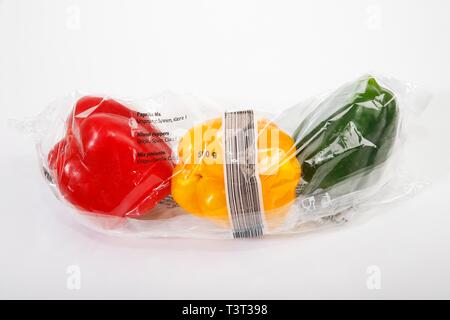 Rosso, giallo e i peperoni verdi (Capsicum annuum) dal supermercato avvolti in una pellicola termocontrattile in plastica, verdure in un imballaggio plastico, rifiuti in plastica Foto Stock