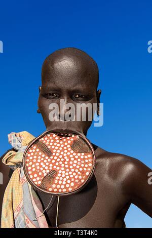 Donna con grande piastra a labbro, la tribù dei Mursi, Parco Nazionale di Mago, regione a sud della nazionalità delle nazioni e dei popoli, Etiopia Foto Stock