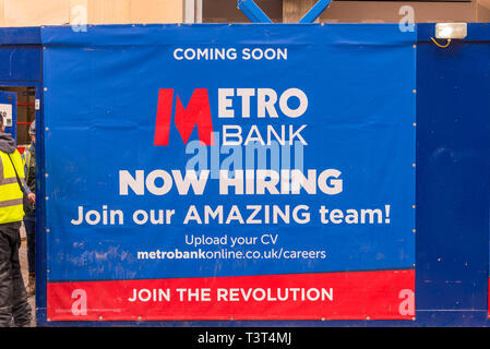 Grande segno sulla palizzata al di fuori del nuovo ramo del metro Bank che aprirà a breve in Birmingham, Regno Unito Foto Stock