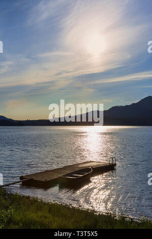 Canoa e dock in legno nel lago in remoto Foto Stock